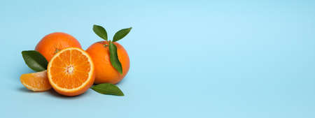 Ripe sweet mandarins on blue background, space for text