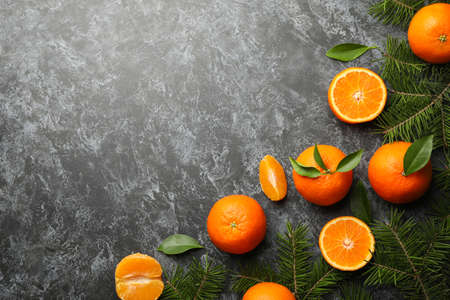 Mandarins and pine branches on gray smoky background