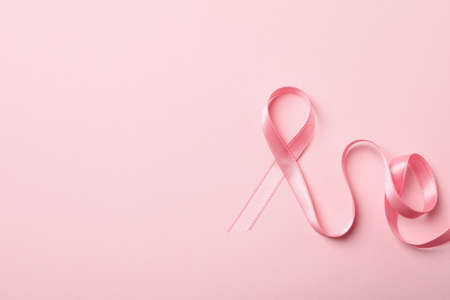 Pink awareness ribbon on pink background, space for textの写真素材