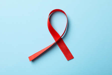 Red awareness ribbon on blue background, close upの写真素材