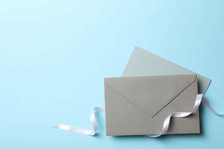 Envelopes with white curly ribbon on blue backgroundの写真素材