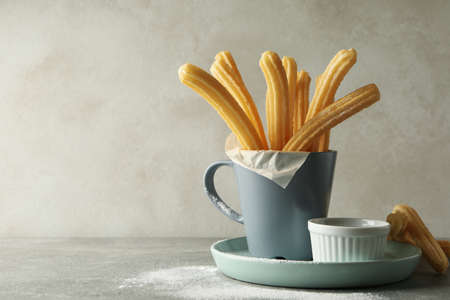 Concept of sweet lunch with churros on gray table