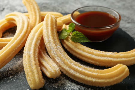 Concept of sweet lunch with churros on gray table