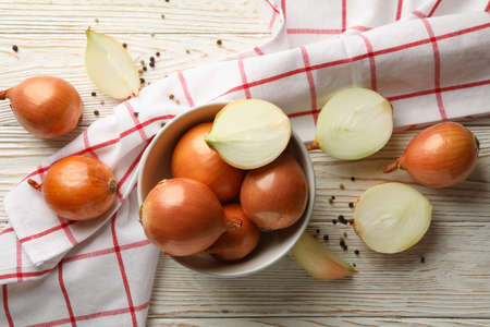 Bowl with fresh onion and napkin on wooden backgroundの写真素材