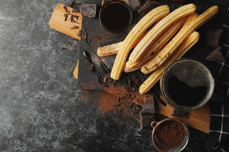 Concept of lunch with churros and chocolate on dark tableの写真素材