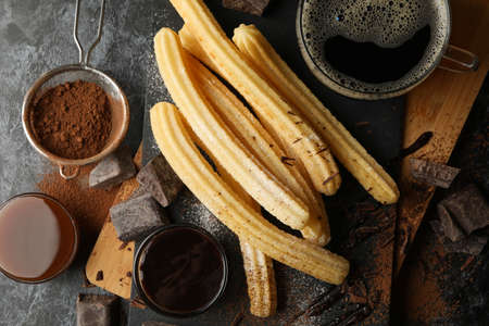 Concept of lunch with churros and chocolate on dark tableの写真素材