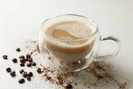 Cup of coffee and coffee beans on white background