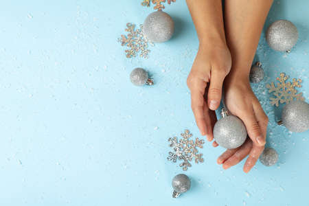 Female hands hold baubles on blue backgroundの写真素材
