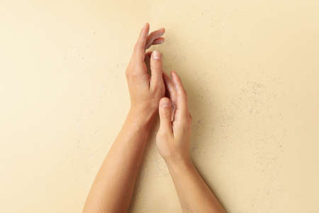 Female hands with glitter on beige background, top viewの写真素材