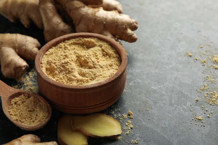 Ginger and bowl with ginger powder on black smoky backgroundの写真素材