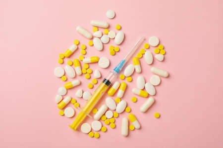 Pills and syringe on pink background, top viewの写真素材
