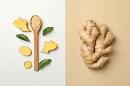 Ginger and spoon with ginger powder on two tone backgroundの写真素材