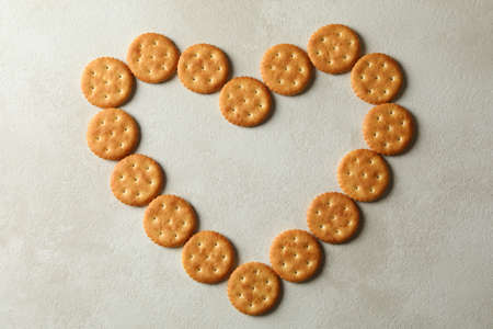 Heart made of tasty cracker biscuits on light backgroundの写真素材