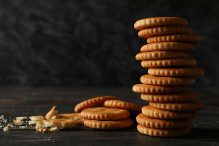 Pile of cracker biscuits on wooden background, space for textの写真素材