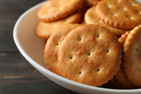 Bowl with tasty cracker biscuits on wooden backgroundの写真素材
