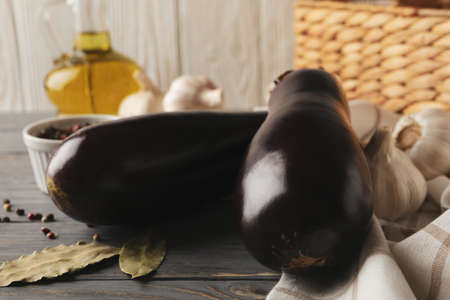 Fresh raw eggplants and spices on wooden backgroundの写真素材