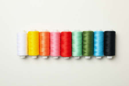 Color sewing threads on white background, space for text