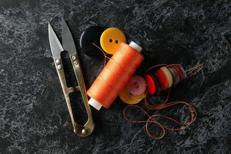 Sewing supplies on black smokey background, top view