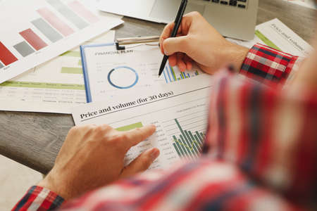 Young man in red shirt is engaged in financial planning