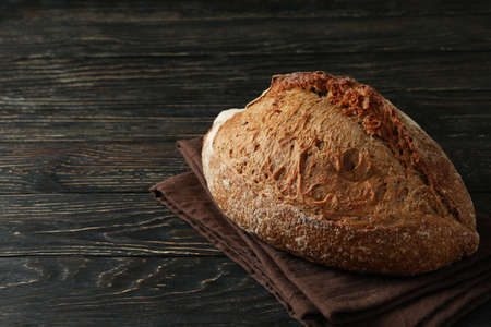 Towel with fresh baked bread on wooden table