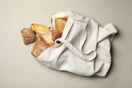 Cotton bag with bakery products on gray background