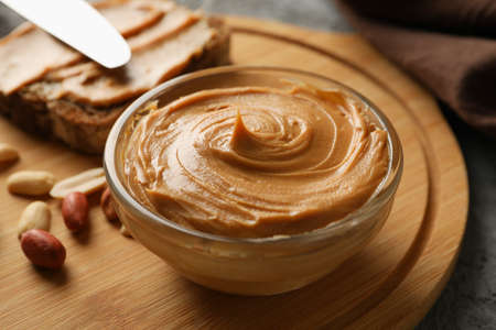 Concept of tasty breakfast with peanut and peanut butter on gray table