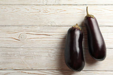 Fresh raw eggplants on white wooden backgroundの写真素材