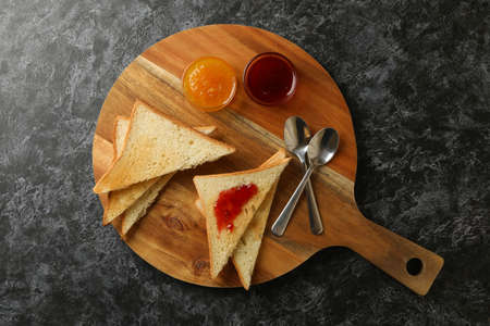Concept of cooking toasts with jam on black smokey background