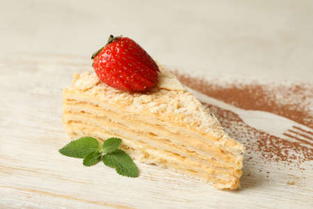 Board with piece of Napoleon cake with strawberry, close up
