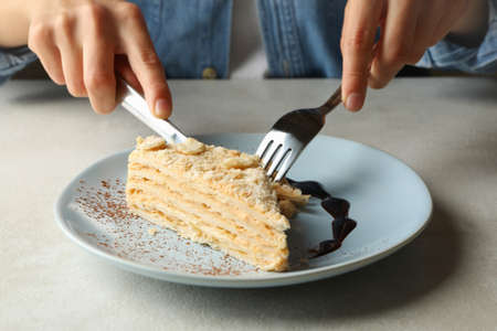 Woman eating delicious Napoleon cake, close up
