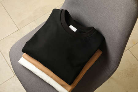 Pile of blank stylish sweatshirts on chairの写真素材