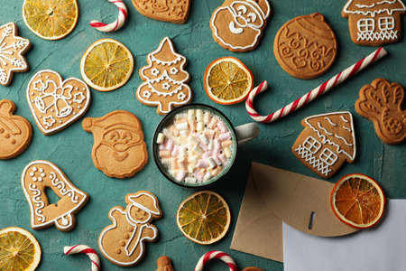Concept with Christmas cookie and cup of cacao on green background, top view
