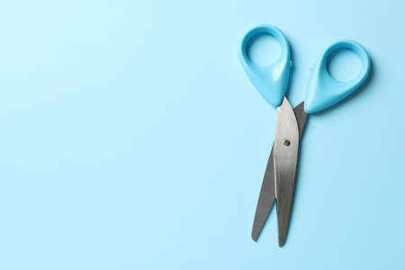 Blue scissors on blue background, space for textの写真素材