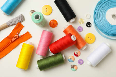 Sewing supplies on white background, top view