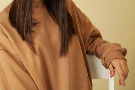 Woman in stylish sweatshirt sitting on chair