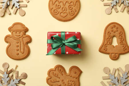 Christmas cookie, gift box and snowflakes on beige backgroundの写真素材