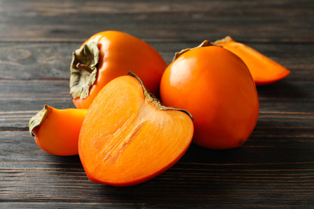 Fresh ripe persimmon on wooden background, close upの写真素材