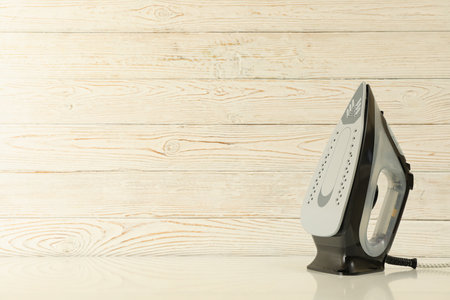 Iron against wooden background, space for textの写真素材