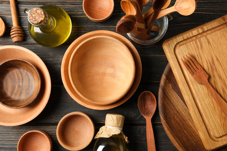 Different wooden kitchenware on wooden table, top view