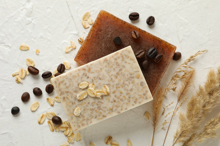 Natural soap, oat and coffee seeds on white tableの写真素材