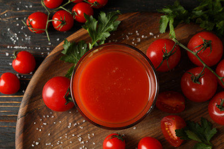 Glass of tomato juice, tomatoes and salt on wooden backgroundの写真素材