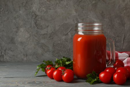 Jar of tomato juice, tomatoes and kitchen towel on wooden backgroundの写真素材