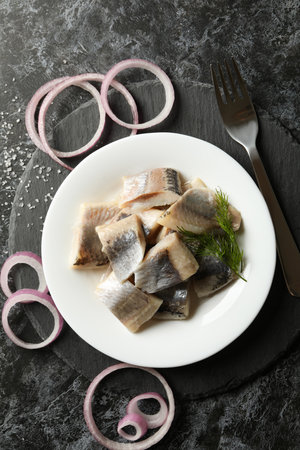 Black tray with plate of fresh herring fish slicesの写真素材
