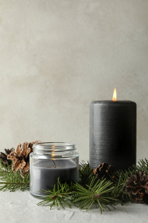 Scented candles and pine branches with cones on white tableの写真素材