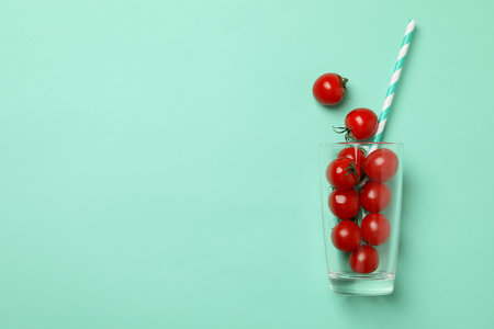 Glass with tomatoes and straw on mint backgroundの写真素材