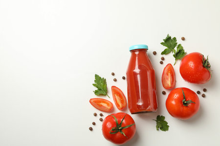 Bottle of tomato juice, tomatoes and spices on white backgroundの写真素材