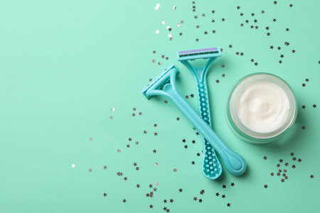 Razoras, glitter and cream on mint background, space for textの写真素材