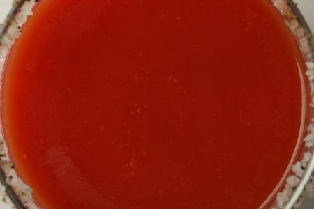 Glass of tomato juice with salt on rim, top view and close upの写真素材