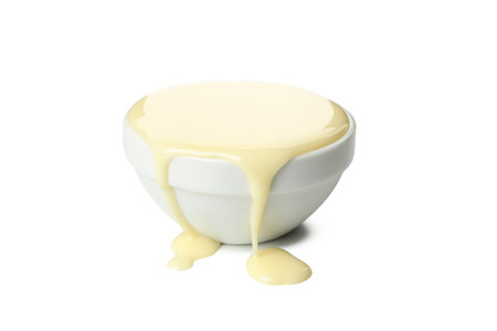 Bowl with condensed milk isolated on white backgroundの写真素材