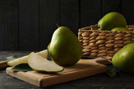 Board and basket with green pears on wooden backgroundの写真素材